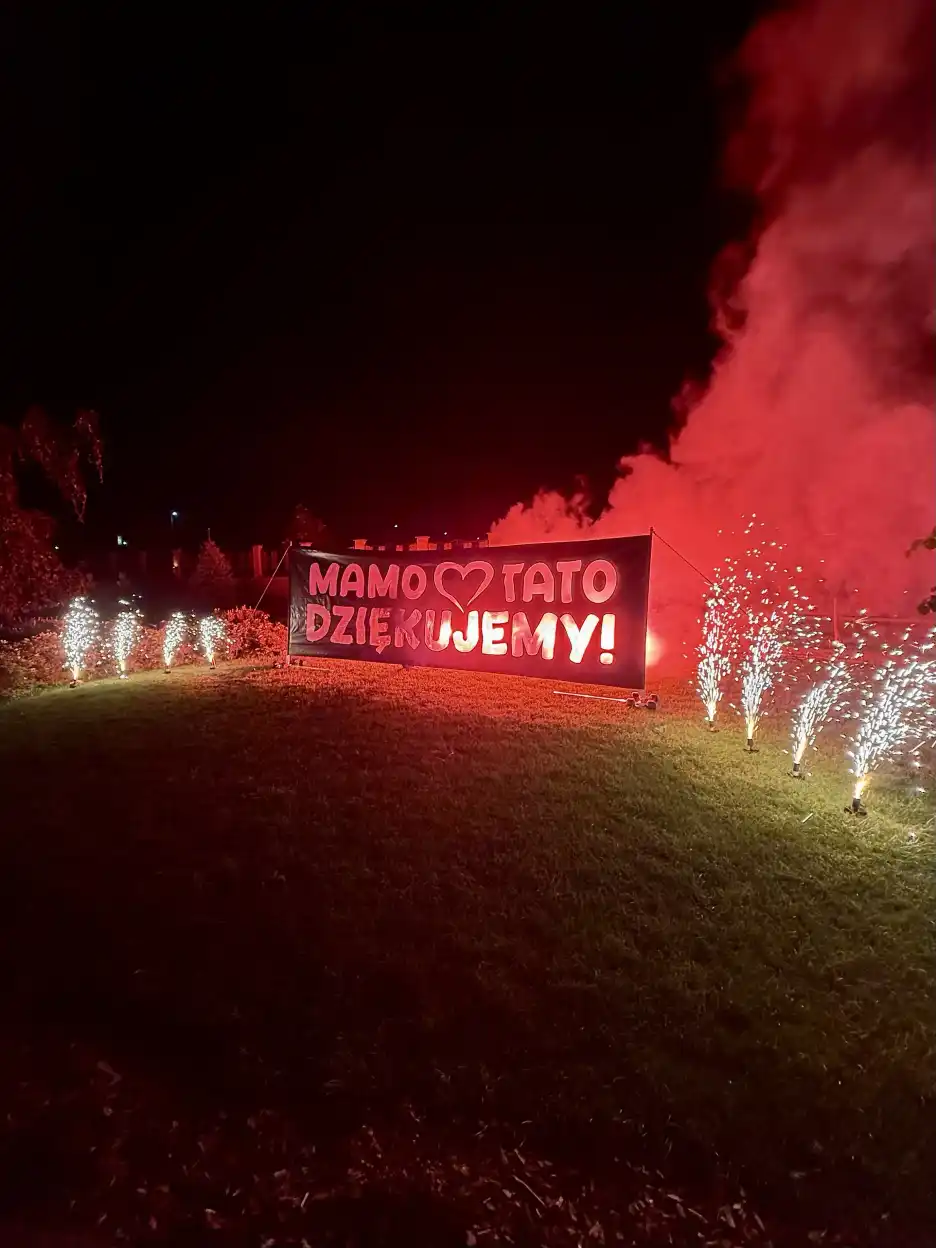 Napis Mamo Tato Dziękujemy podświetlony na czerwono z Fontannami iskier